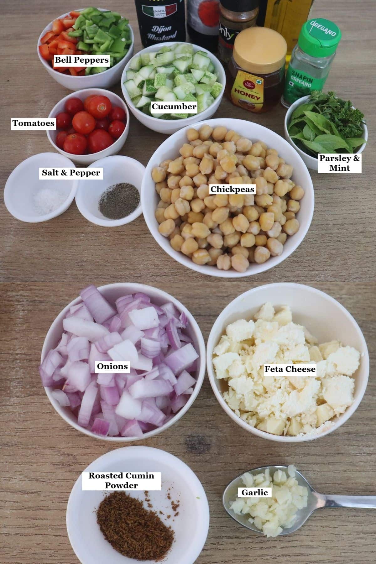 individually labelled ingredients to make Mediterranean chickpea salad with feta are laid out on a table.