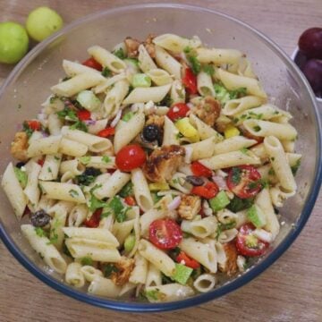 Cold lemon chicken pasta salad with feta in a glass bowl.