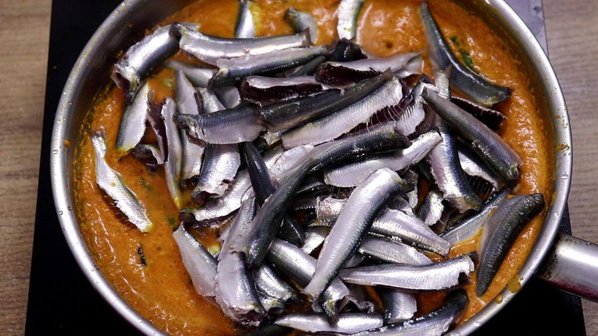 Sardines added to the simmering coconut masala.