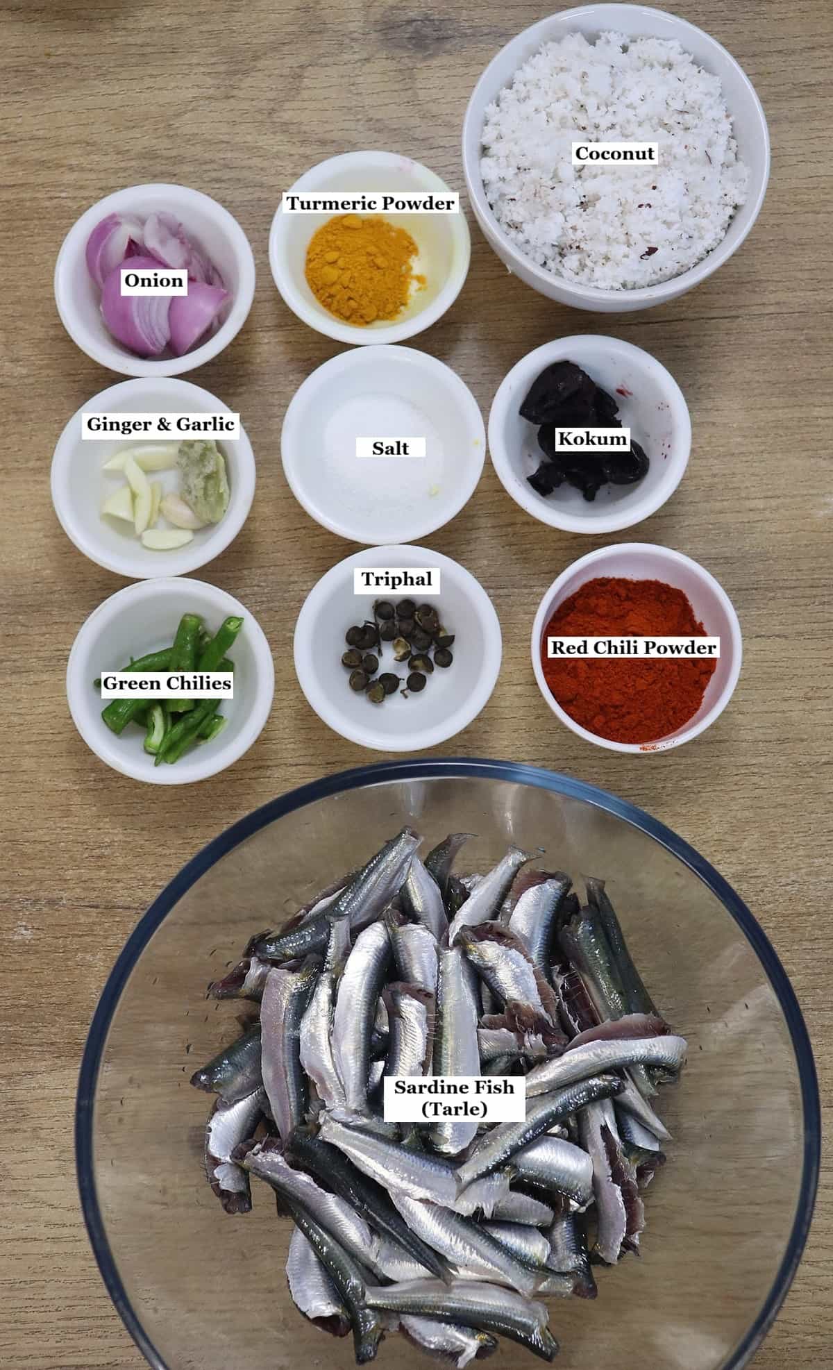 individually labelled ingredients to make fish sukka recipe are laid out on a table.