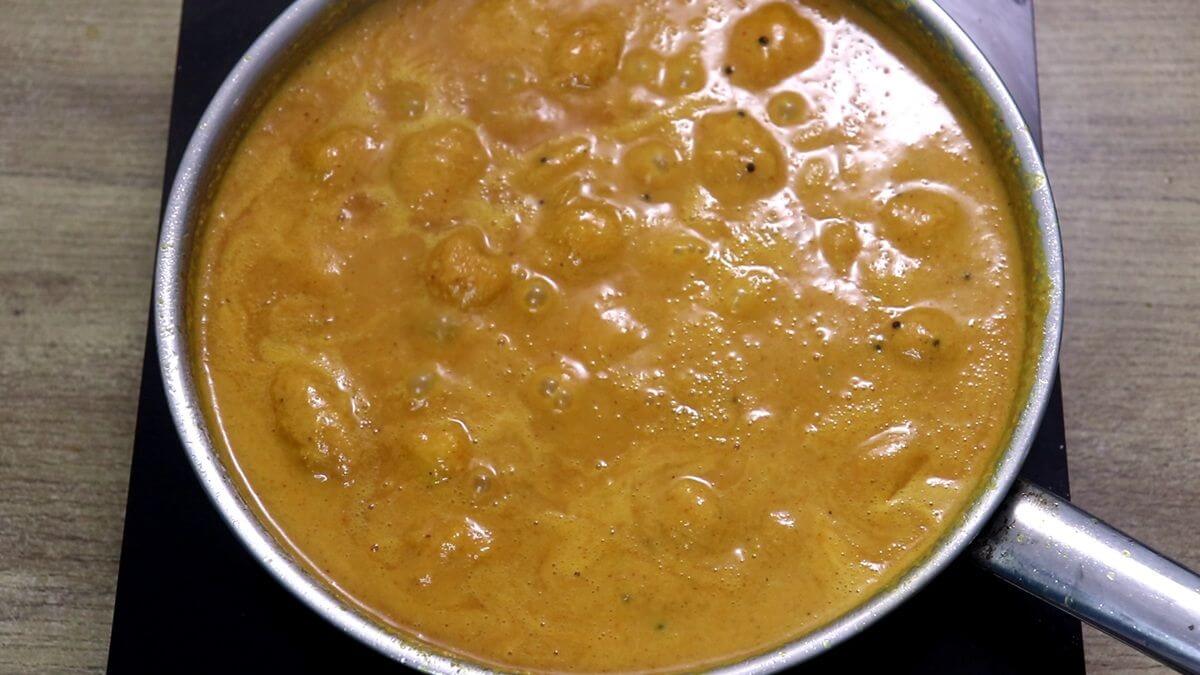 mango sasav curry simmering in the pan.