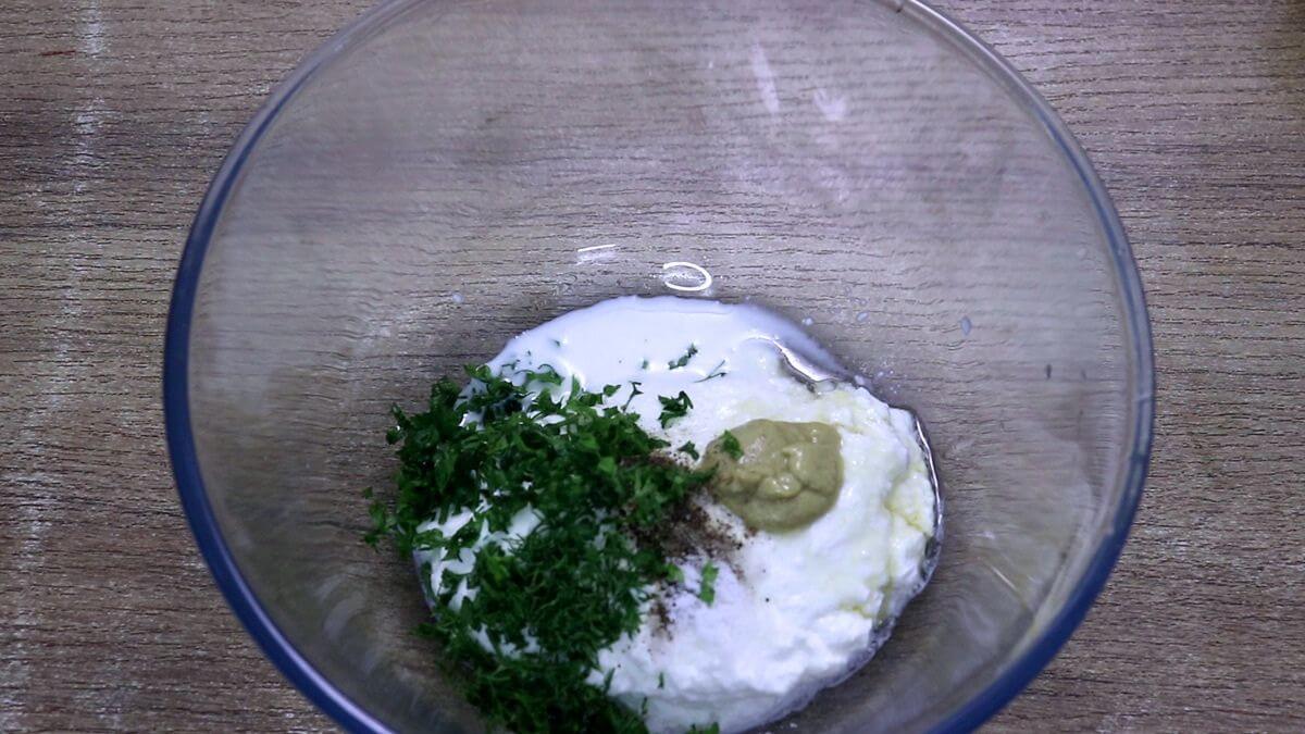 Greek yogurt dressing for Mediterranean chicken salad being mixed in a bowl.