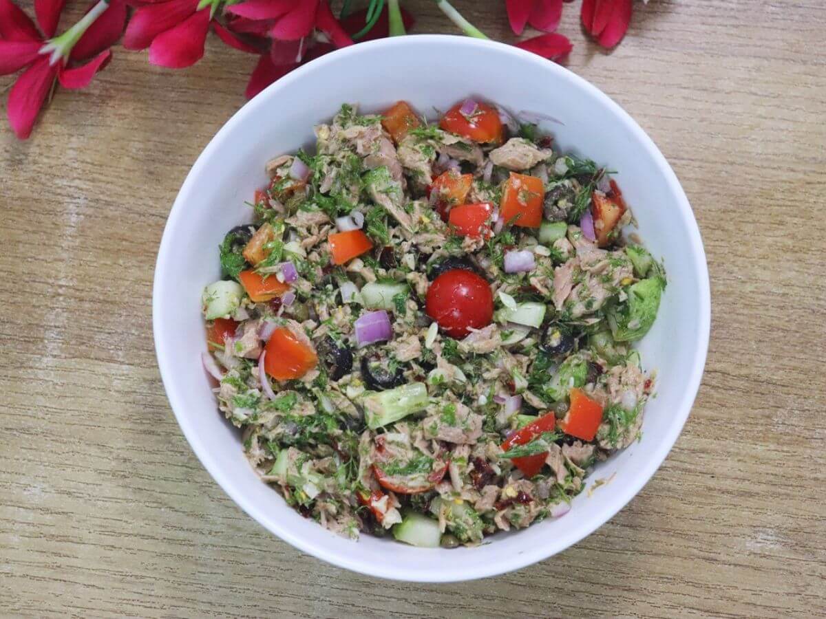 Mediterranean tuna salad with tuna, cucumber, olives, feta cheese, cherry tomatoes, and fresh herbs.