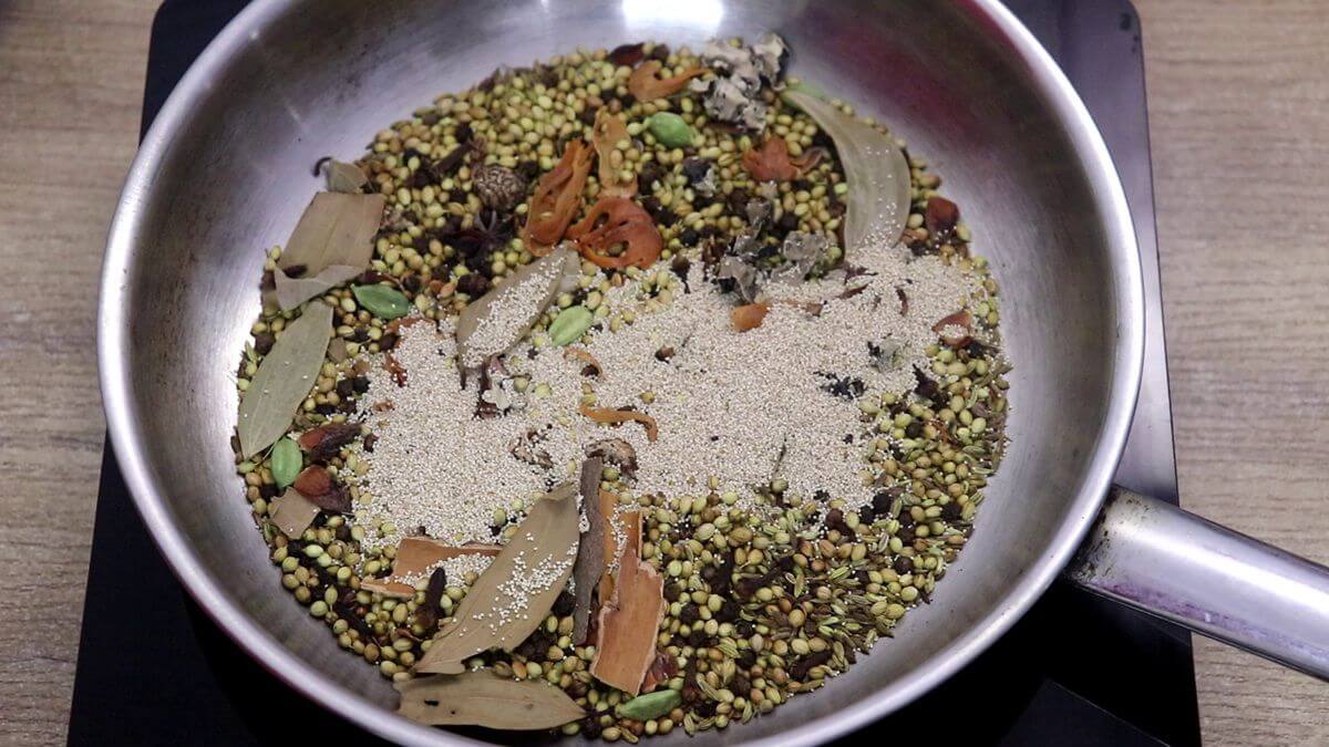 Adding poppy seeds while roasting spices for Xacuti masala powder.