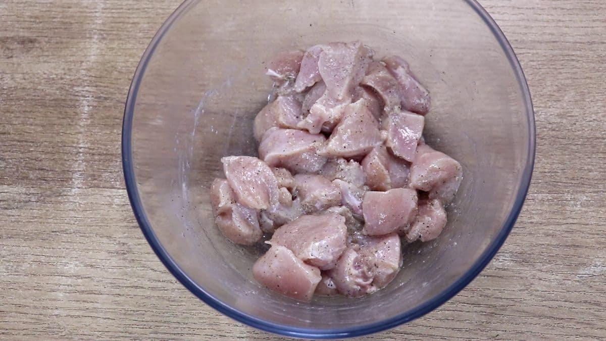 Chicken breast marinating with lemon juice, olive oil, salt, and black pepper for lemon garlic chicken.