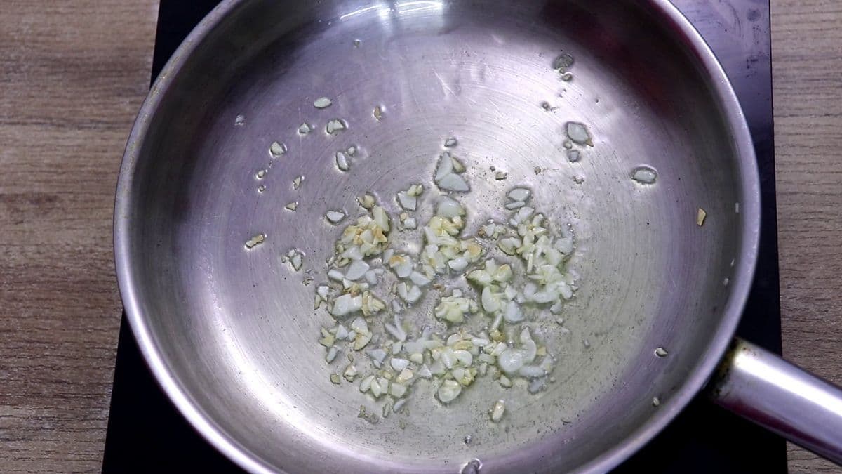 Minced garlic sautéing in olive oil for lemon garlic chicken.