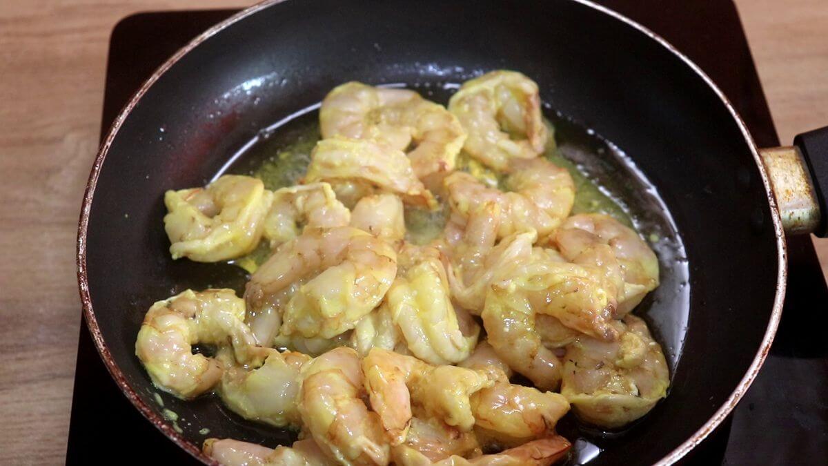 Marinated prawns frying in ghee for Mangalorean prawn ghee roast.