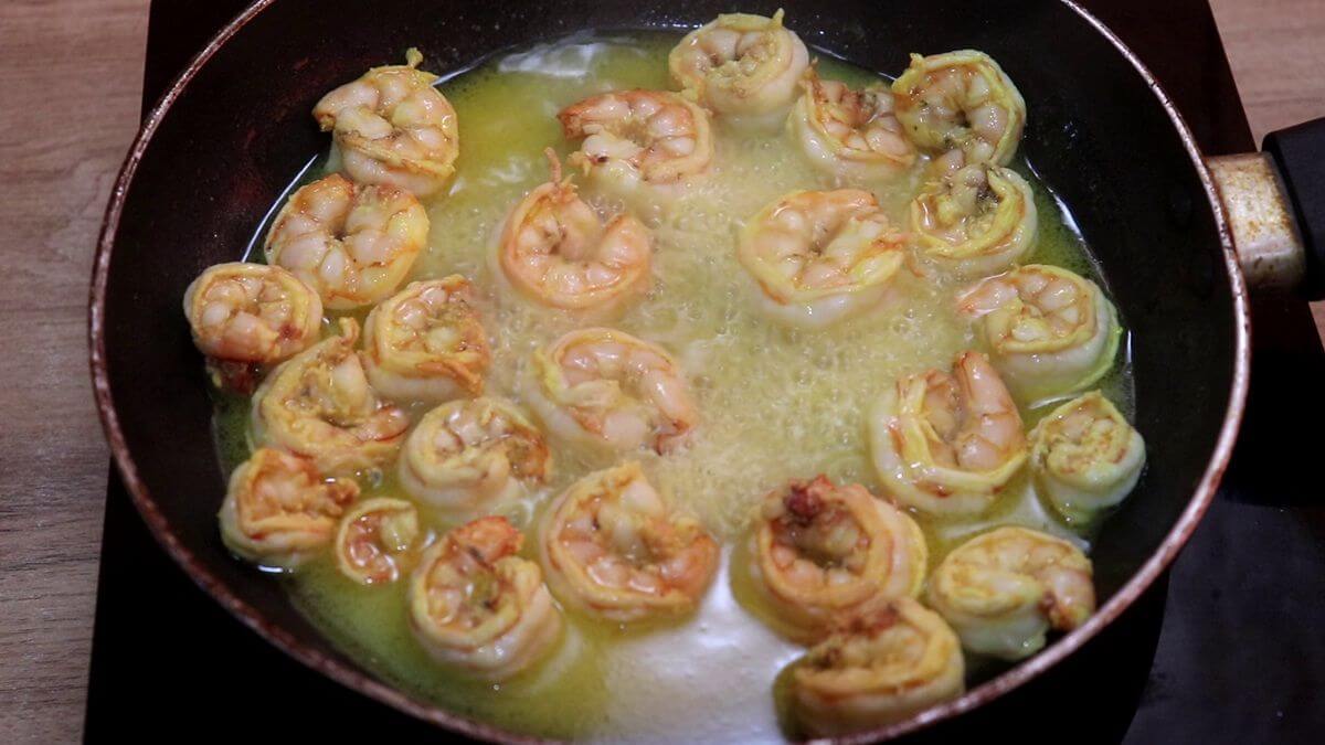 Prawns releasing flavorful juices while cooking in ghee.