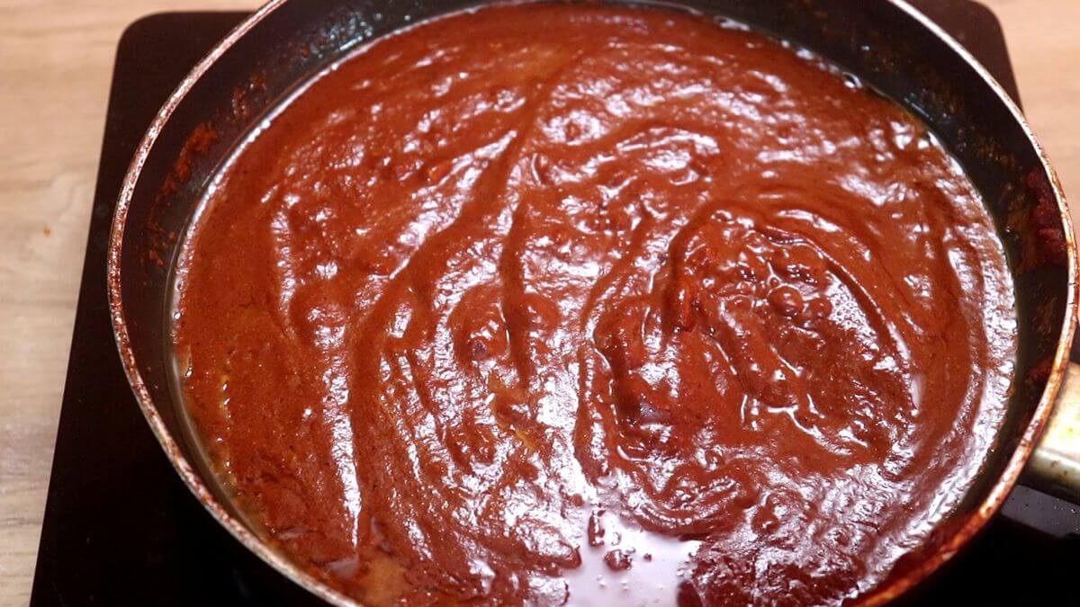 Homemade ghee roast masala and reserved prawn stock cooking together.