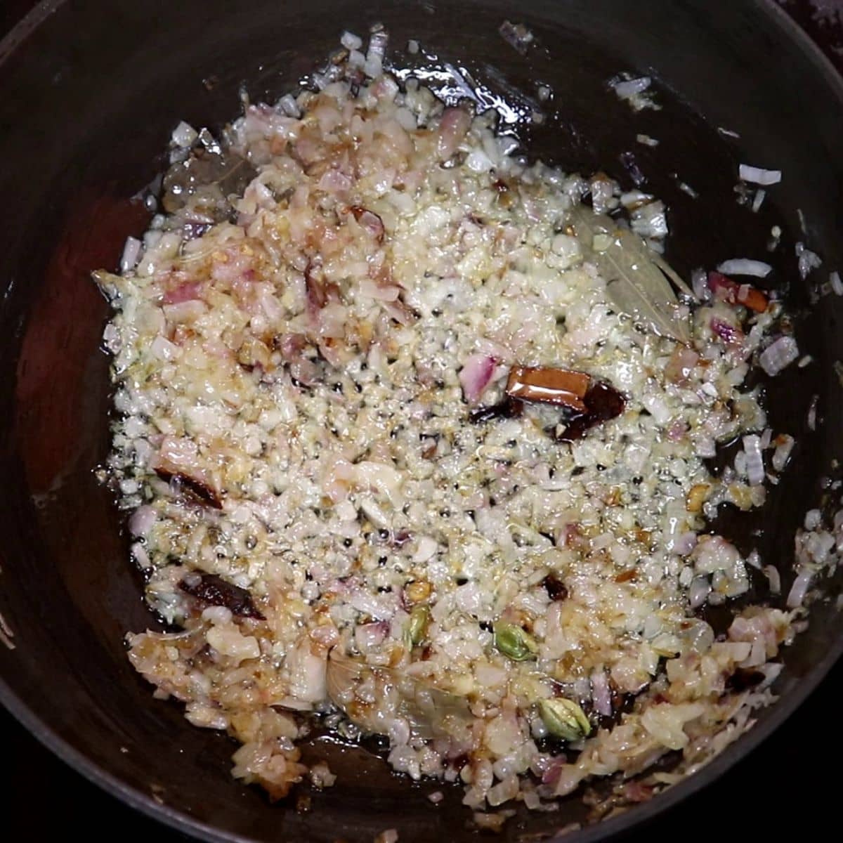 Onions sautéed until golden for dahi chicken curry.