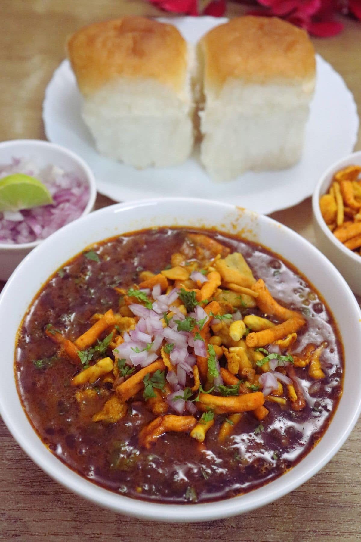 Spicy Kolhapuri Misal Pav served with pav, farsan, onions and lemon.