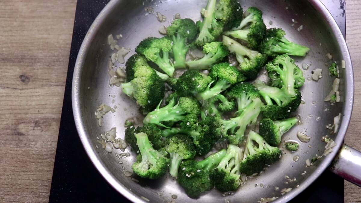 Broccoli tossed in lemon garlic sauce in a pan.
