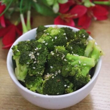 Mediterranean lemon garlic broccoli served in a bowl, garnished with sesame seeds.