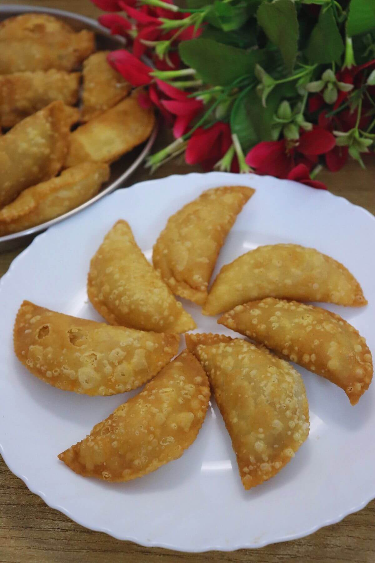 Goan Pittachyo Neureo stuffed with sweet roasted moong dal filling are arranged on a plate.